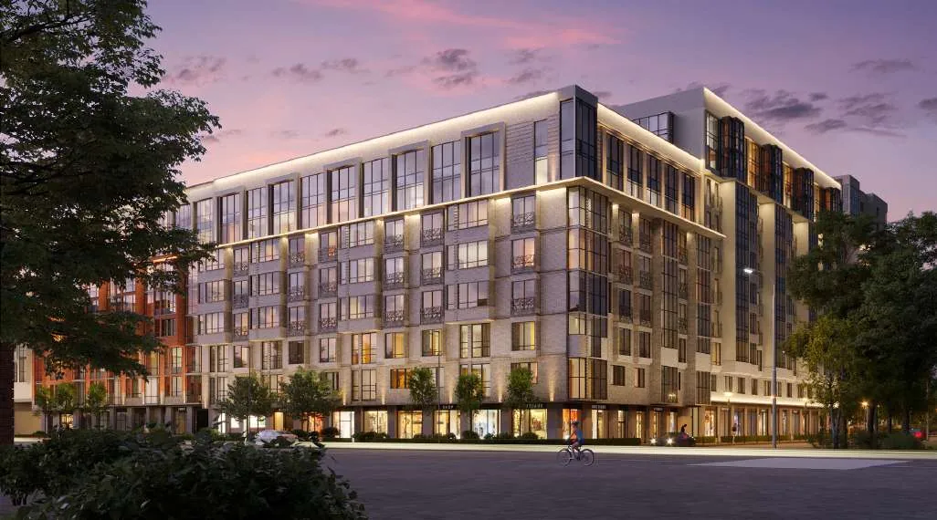 Luxury mid-rise residential building at sunset, featuring modern architecture and illuminated facade, developed by Al Ayid Fund LLC for high-end urban living.